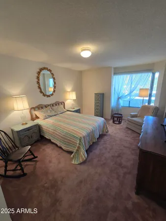 a bedroom with a bed mirror and window