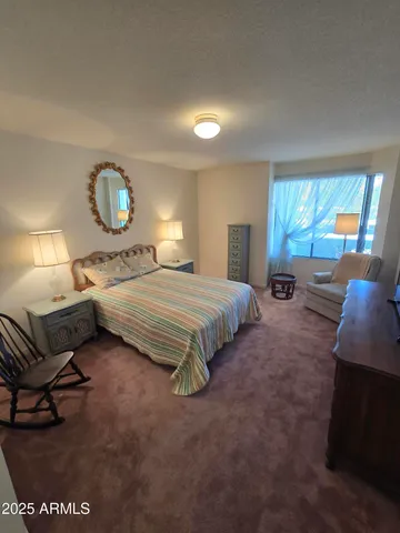 a bedroom with a bed mirror and window