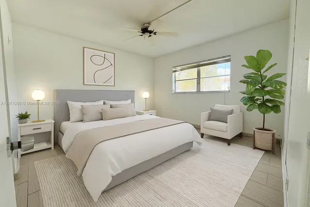 a bedroom with a bed lamp and a potted plant