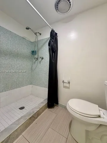 a bathroom with a toilet and a shower