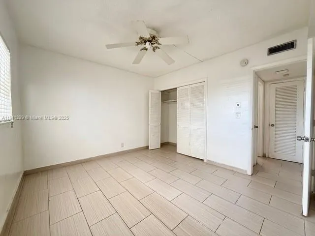 an empty room and chandelier fan