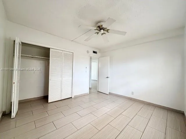 a view of an empty room and chandelier fan