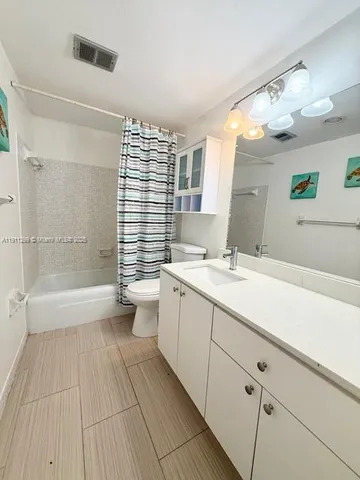 a spacious bathroom with a shower a sink and a mirror