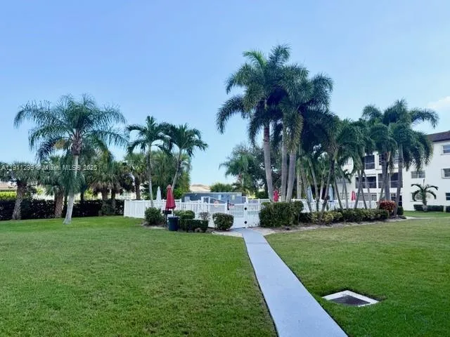 a front view of a house with a garden and trees