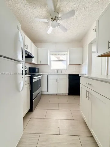 a kitchen with stainless steel appliances granite countertop a stove sink and cabinets