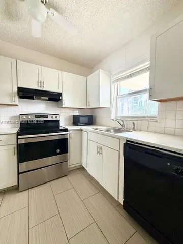 a kitchen with cabinets appliances and a window