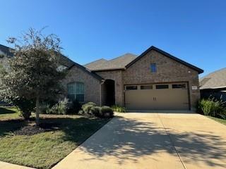 A classic brick facade welcomes you home, complete with an attached garage and neatly kept landscaping.
