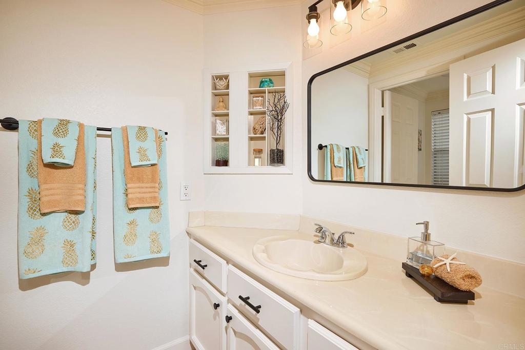 1134 Calle Christopher Encinitas, CA 92024 - Photo 16 of 37 a bathroom with a granite countertop sink and a mirror