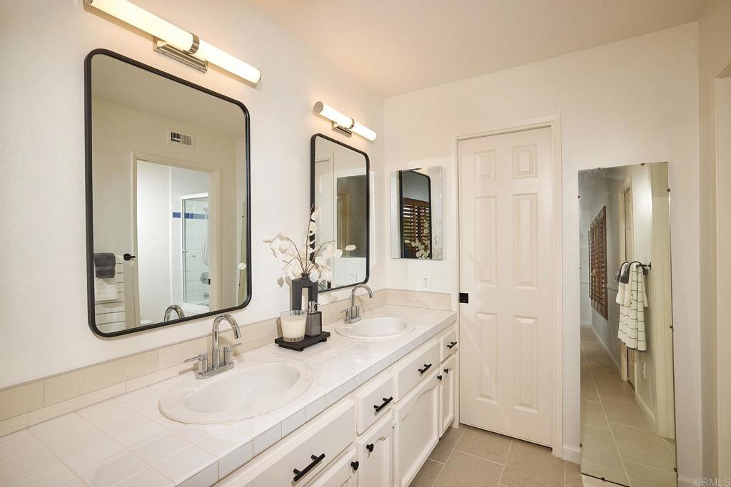 1134 Calle Christopher Encinitas, CA 92024 - Photo 24 of 37 a bathroom with double vanity sinks and a mirror
