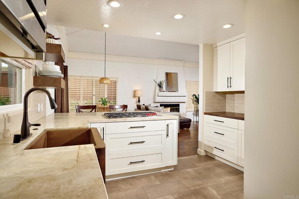 1134 Calle Christopher Encinitas, CA 92024 - Photo 8 of 37 a kitchen with granite countertop a stove sink and cabinets