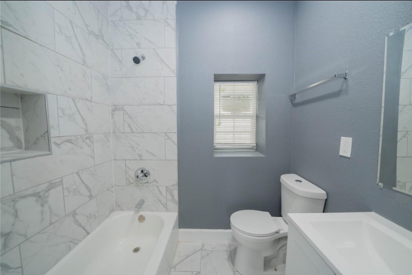 1426 Telephone Road, Unit 1BD Houston, TX 77023 - Photo 3 of 10 a white toilet sitting next to a bath tub
