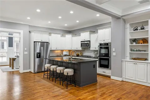 a kitchen with stainless steel appliances granite countertop a refrigerator and a stove top oven