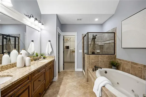 a bathroom with a granite countertop tub sink a mirror and shower