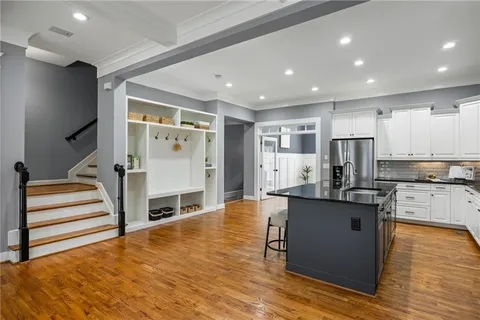 a kitchen with stainless steel appliances granite countertop a refrigerator and a stove top oven