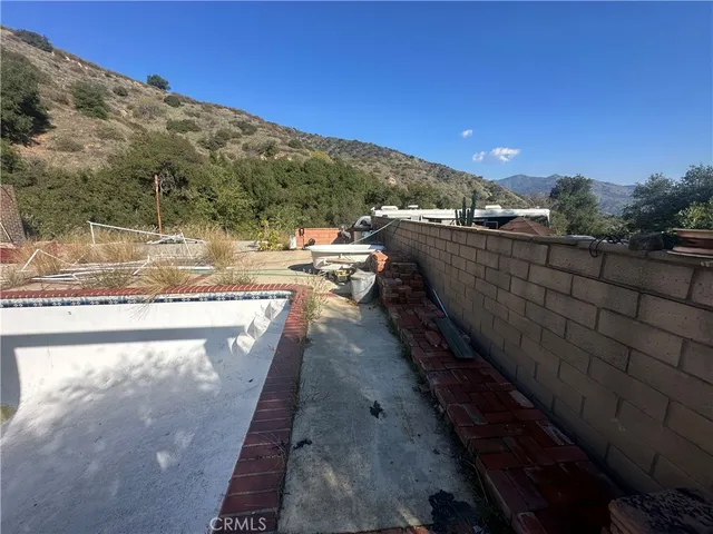 a view of a swimming pool with a lounge chair and a fire pit