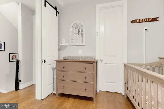 a view of a bedroom with wooden floor