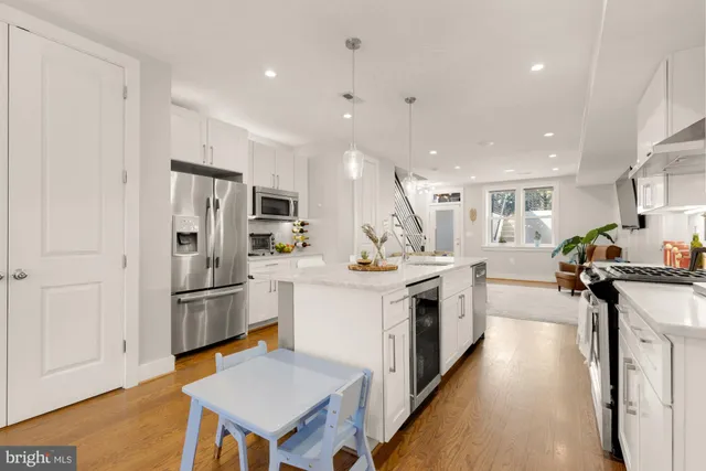 a kitchen with stainless steel appliances kitchen island sink refrigerator and cabinets