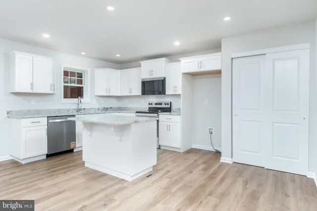a kitchen with stainless steel appliances granite countertop a sink stove and microwave