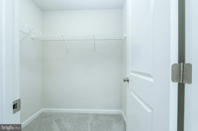 a view of a hallway with wooden floor and a living room