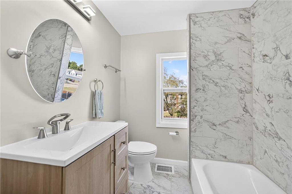1106 Wade Street Aliquippa, PA 15001 - Photo 12 of 32 a bathroom with a sink a toilet and a mirror