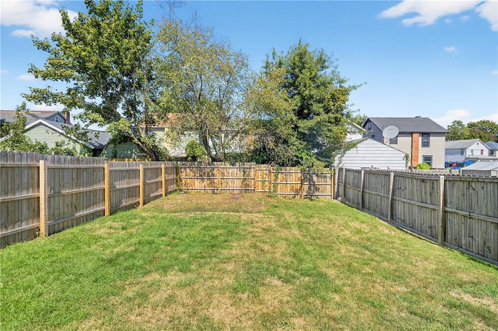 1106 Wade Street Aliquippa, PA 15001 - Photo 25 of 32 a view of a backyard with large trees and wooden fence