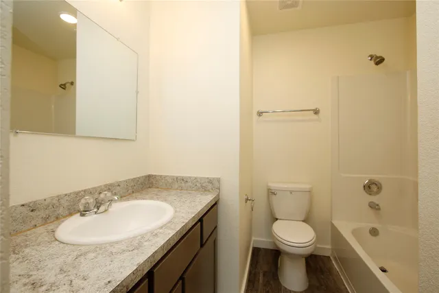 a bathroom with a granite countertop sink toilet and shower