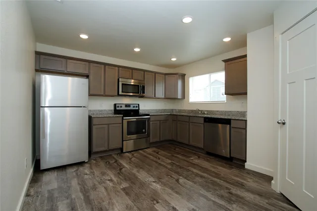 a kitchen with a refrigerator a microwave a sink and a stove