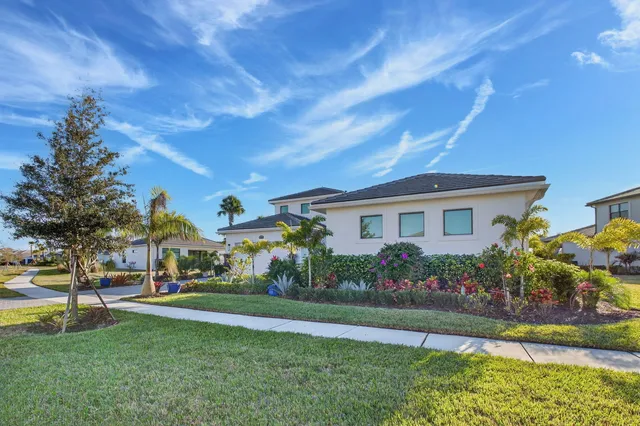 a front view of a house with a yard and potted plants