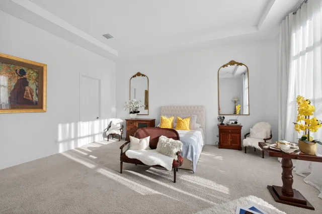 a spacious bedroom with a bed and a lamp