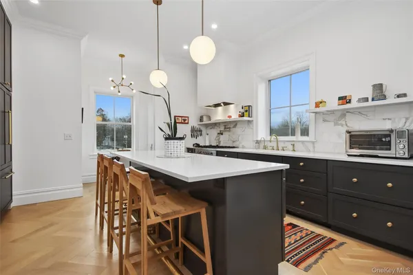a kitchen with stainless steel appliances granite countertop a sink a stove and a wooden floors