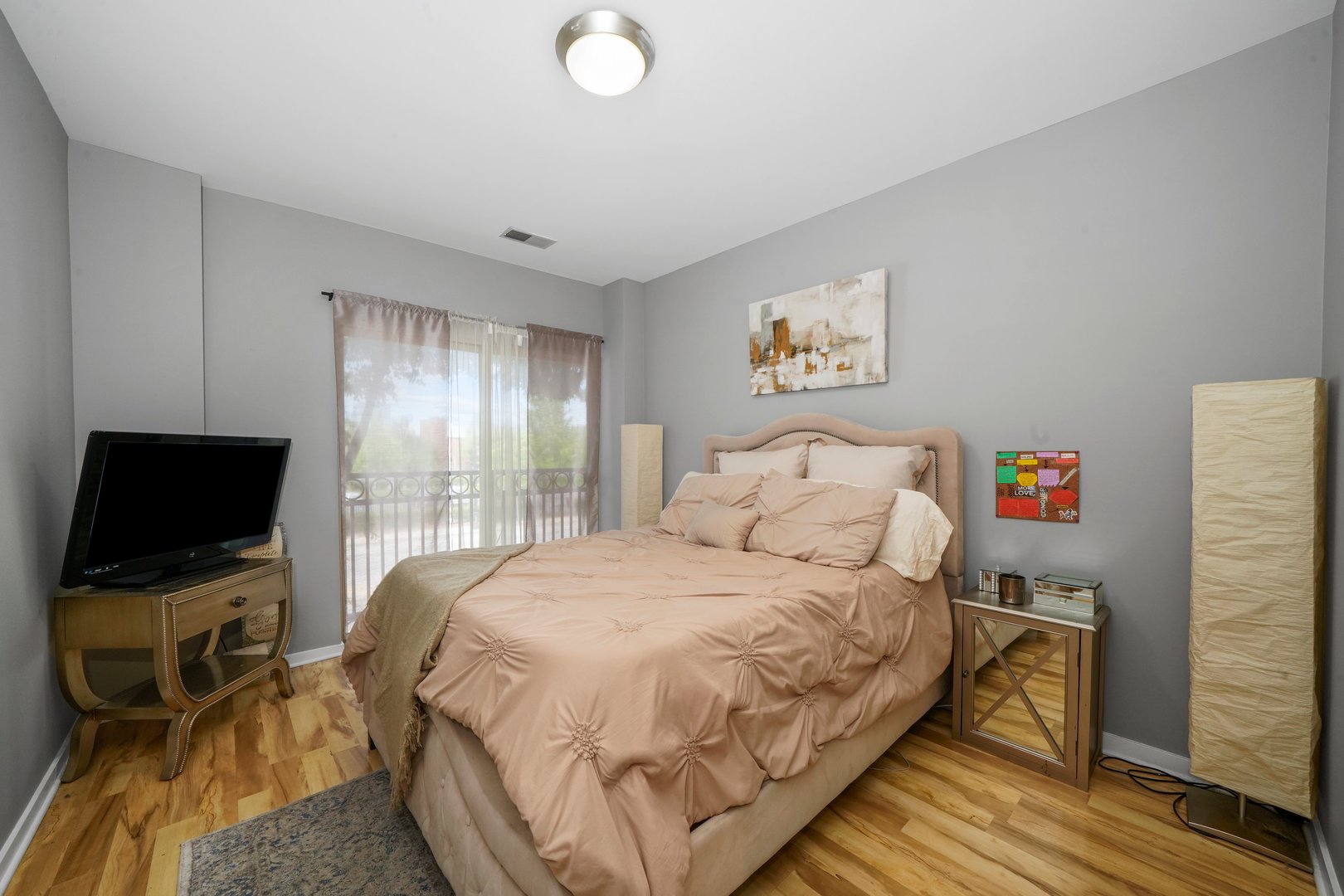 1155 West Roosevelt Road, Unit 210 Chicago, IL 60608 - Photo 12 of 24 a bedroom with a bed and a flat screen tv