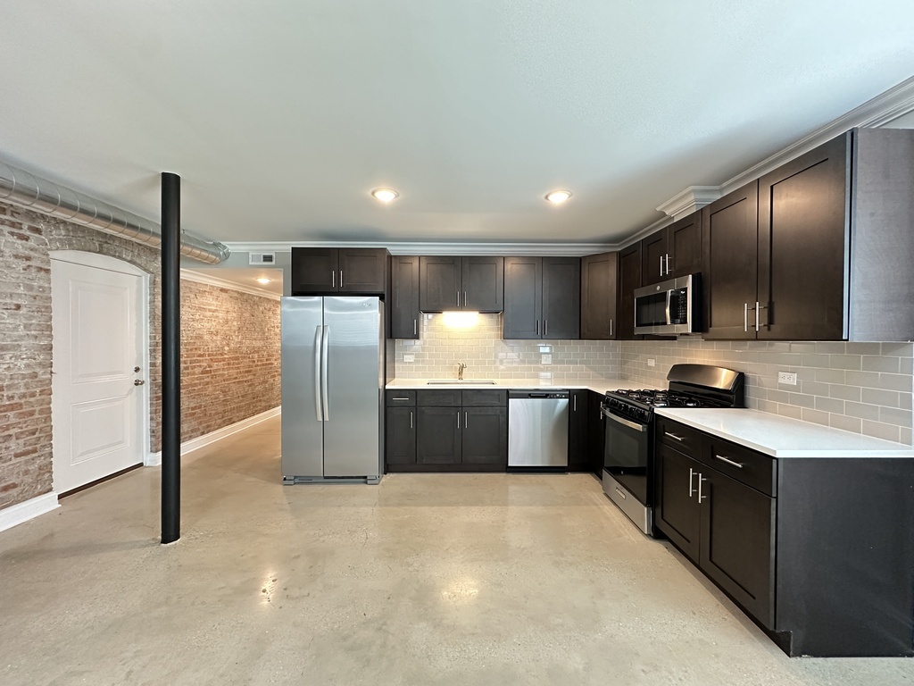 4117 South Michigan Avenue, Unit GS Chicago, IL 60653 - Photo 2 of 20 a large kitchen with a large counter top stainless steel appliances and cabinets