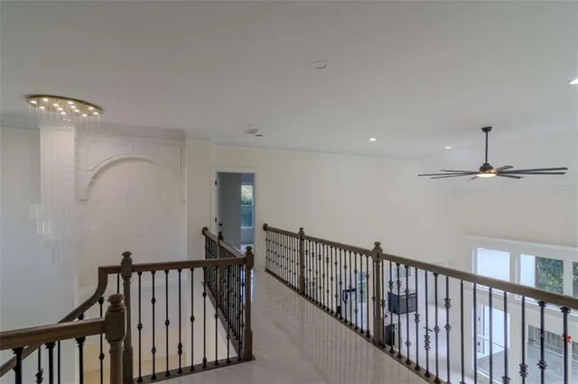 a view of staircase with railing and a chandelier