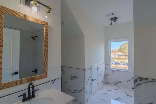 a bathroom with a bathtub a sink and a mirror