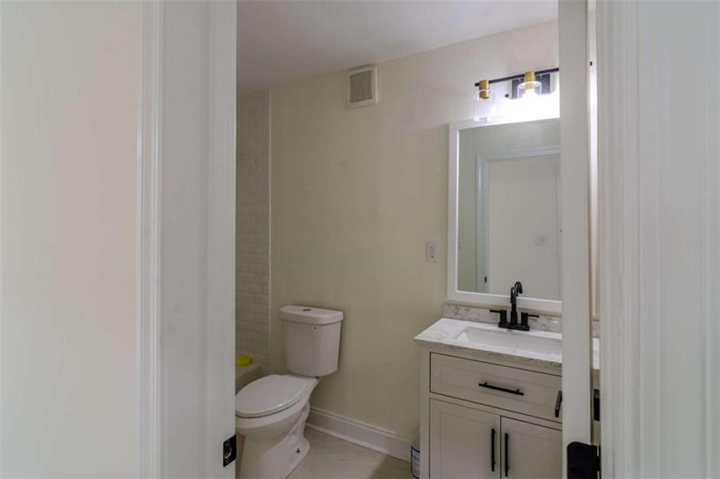 4822 Chamblee Dunwoody Road Atlanta, GA 30338 - Photo 34 of 65 a bathroom with a toilet sink and mirror
