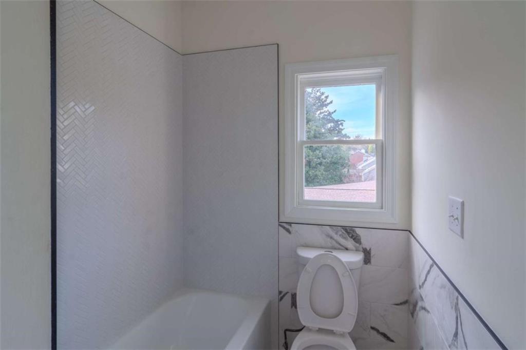 4822 Chamblee Dunwoody Road Atlanta, GA 30338 - Photo 53 of 65 a bathroom with a granite countertop toilet a sink and bathtub