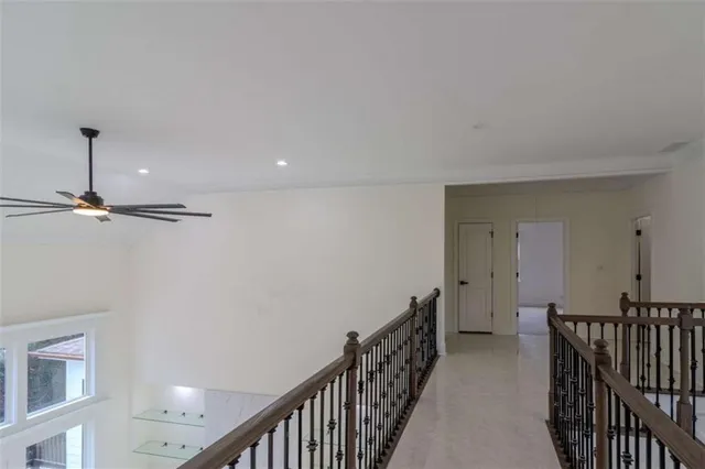 a view of a hallway with wooden floor and staircase