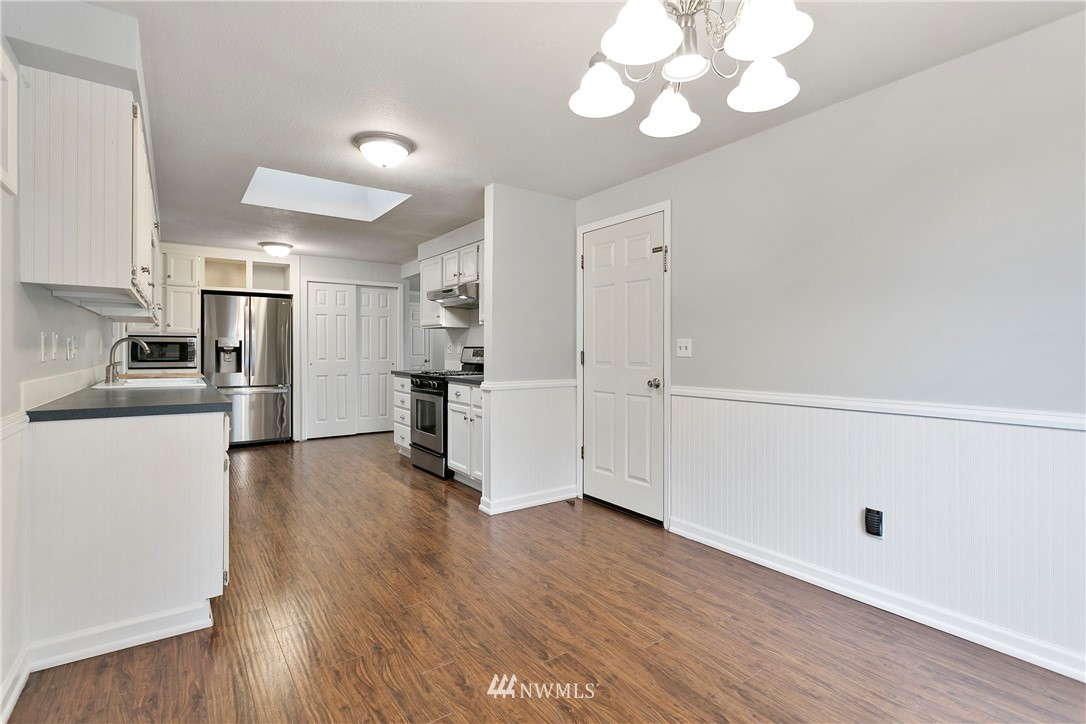 8620 Bender Road Lynden, WA 98264 - Photo 12 of 37 a view of a kitchen with a refrigerator a stove top oven and wooden floor