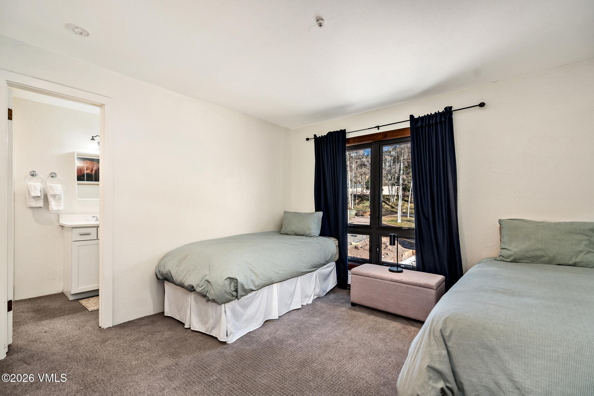 963 Lions Ridge Loop, Unit 502 Vail, CO 81657 - Photo 19 of 30 a bedroom with a bed lamp and a large window