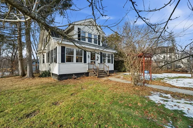 a view of a white house with a yard covered in snow