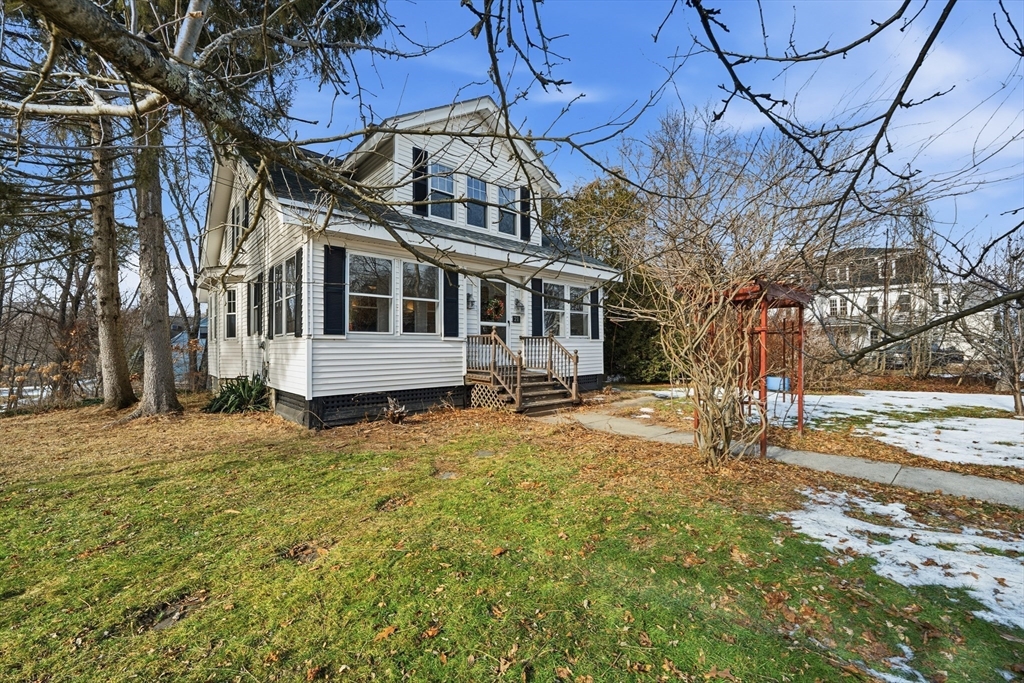 a view of a white house with a yard covered in snow