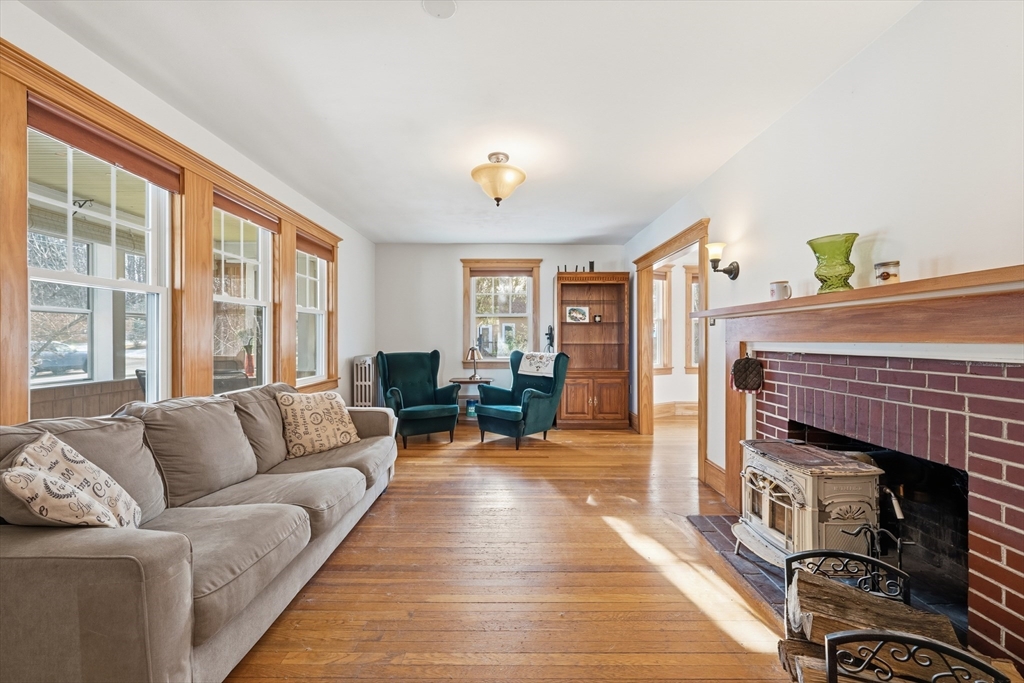 21 High Street Pepperell, MA 01463 - Photo 10 of 40 a living room with furniture a wooden floor and a fireplace
