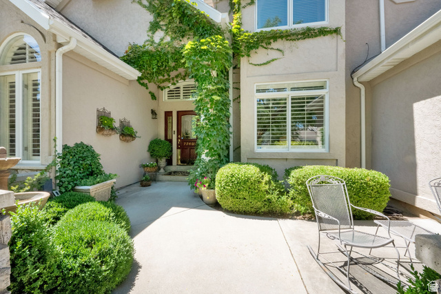 7740 Keswick Road Sandy, UT 84093 - Photo 8 of 74 Stucco exterior featuring extensive green vine accents and manicured shrubbery
