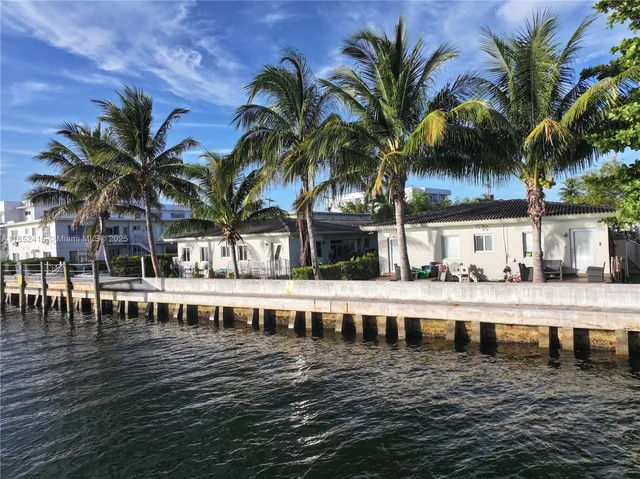 a view of a swimming pool with a chair and palm trees