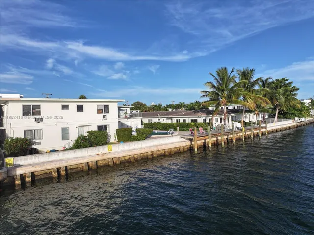 a view of swimming pool with lawn chairs and iron fence