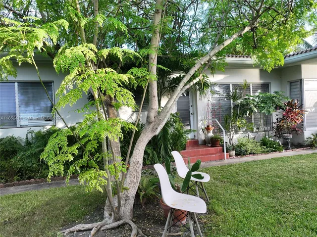a view of a chair and table in backyard of the house