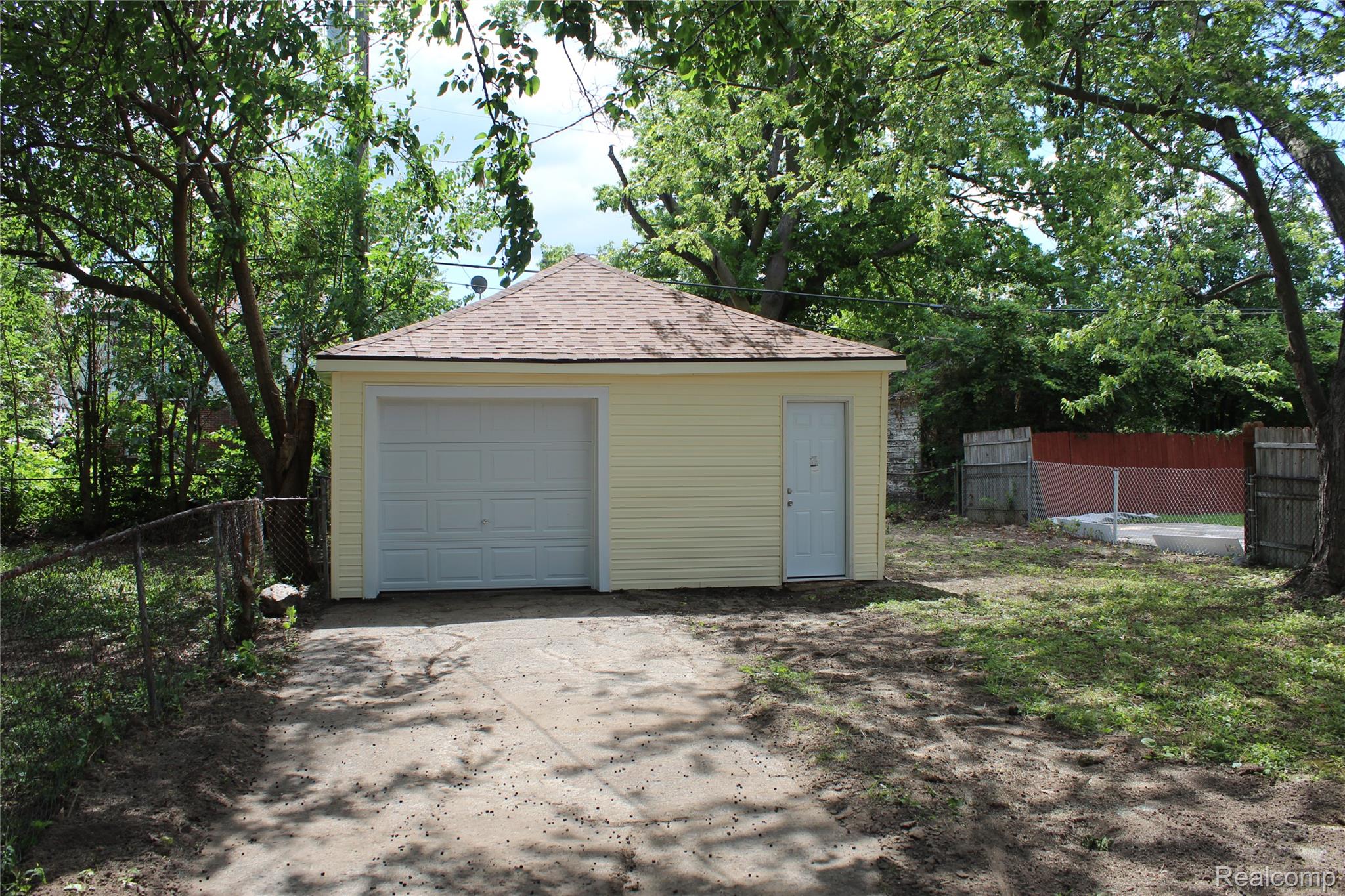 5543 Balfour Road Detroit, MI 48224 - Photo 3 of 54 Detached garage with yellow siding and a peaked shingle roof
