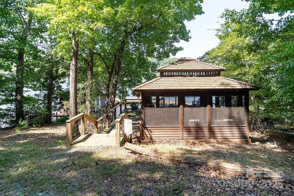 a view of a small house with a large window and yard