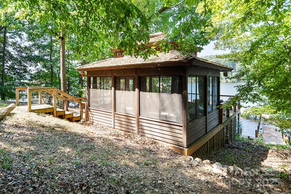 a view of a house with wooden walls next to a yard