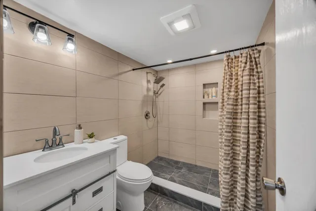 a bathroom with a sink a toilet and shower